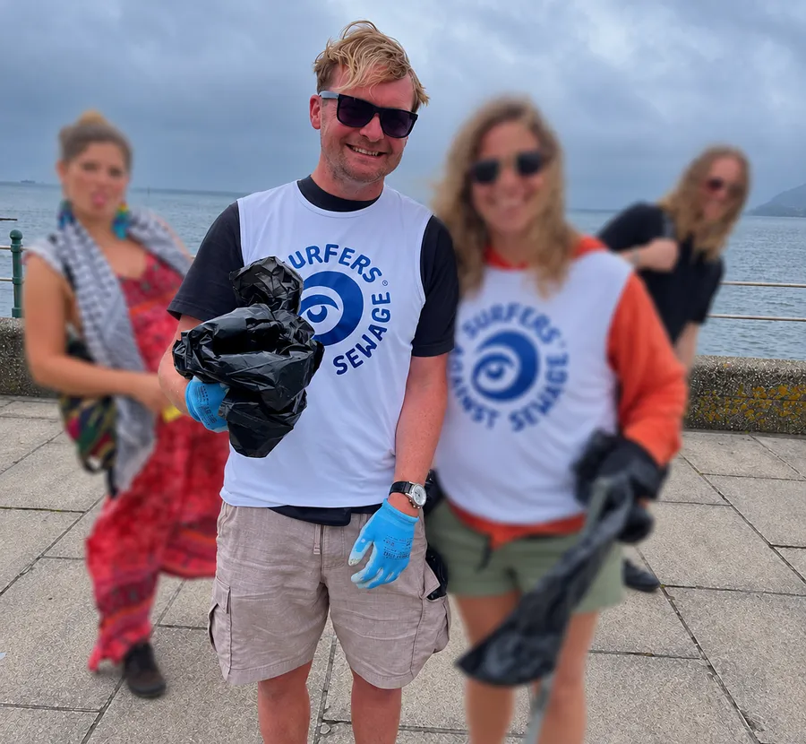 Tom taking part in a beach clean with Surfers Against Sewage, with fellow participants blurred